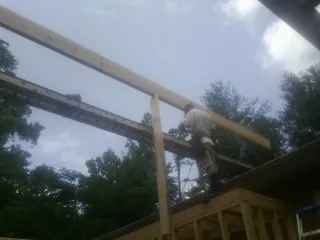 Carpenter setting a ridge beam over a new addition frame — Ice Dam Removal by Roofing Brothers in Maitland